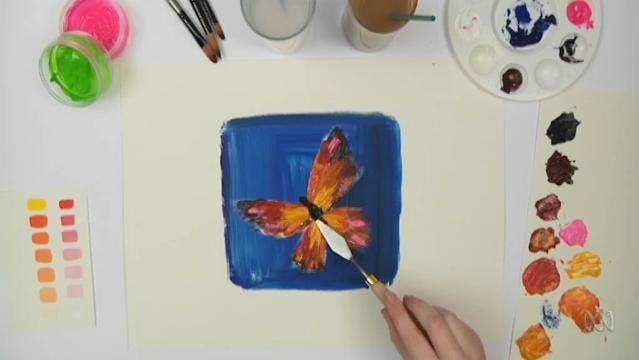 Hand uses palette knife to paint a butterfly