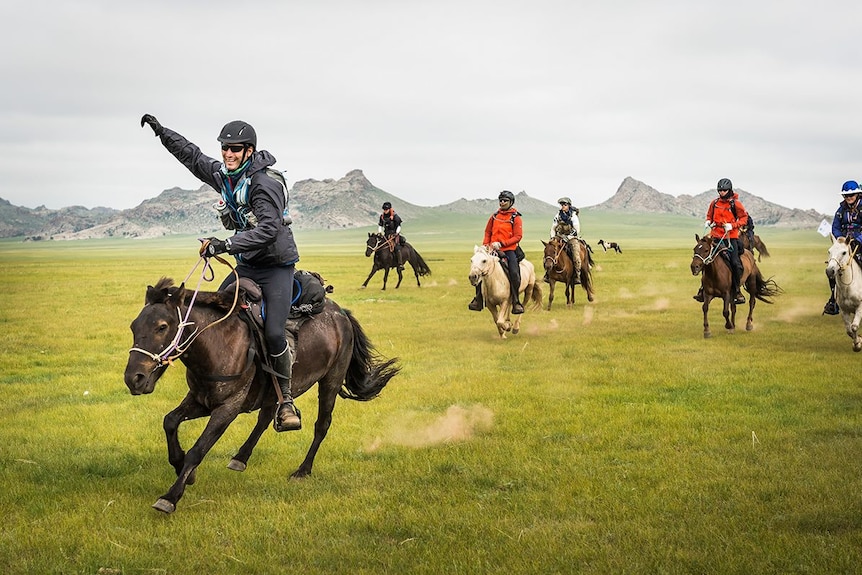 Riders take off across the Mongolian steppe