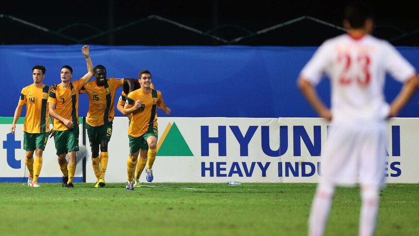 Corey Gameiro (2 L) celebrates on his way to a crucial hat-trick for the Young Socceroos.