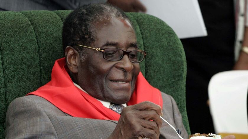 Zimbabwe's President Robert Mugabe eats cake during celebrations for his 85th birthday.