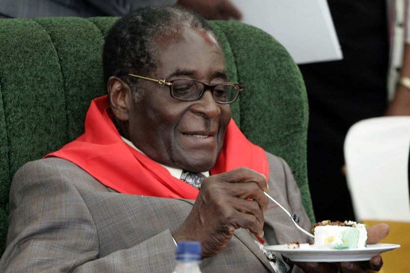 Zimbabwe's President Robert Mugabe eats cake during celebrations for his 85th birthday in Chinhoyi