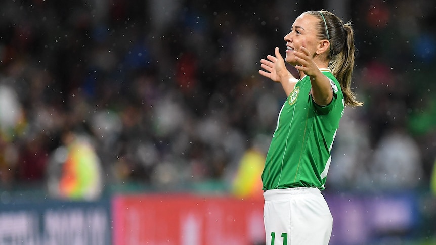 An Ireland player smiles and stands with arms wide acknowledging the crowd after scoring a goal at the Women's World Cup.