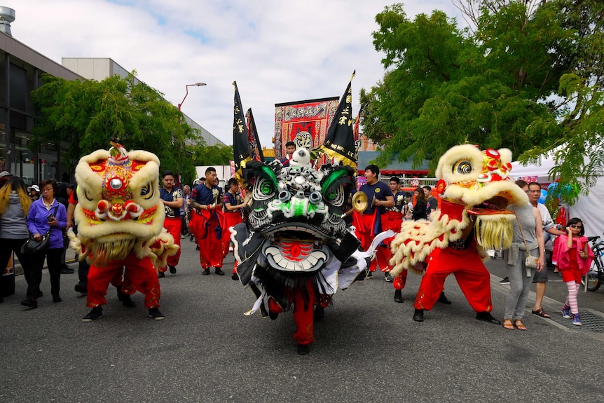 People in colourful lion costumes walk in a Lunar New Year Festival parade in Springvale, Victoria.