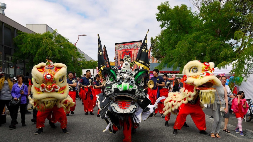 People in colourful lion costumes walk in a Lunar New Year Festival parade in Springvale, Victoria.