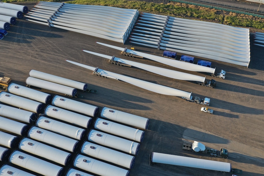 Aerial view of several wind turbine blades loaded onto trucks.
