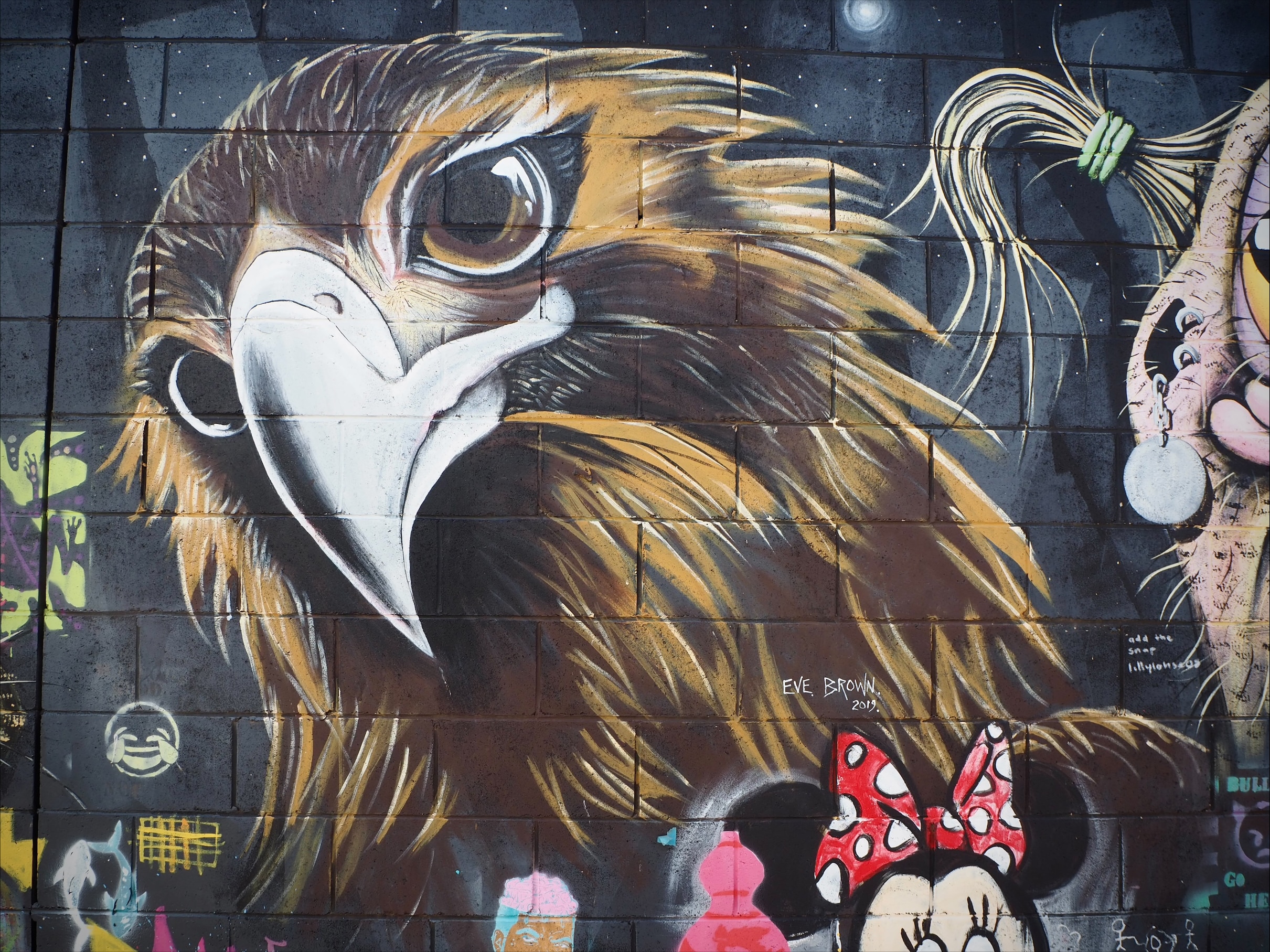 Gran mural con águila en el callejón.