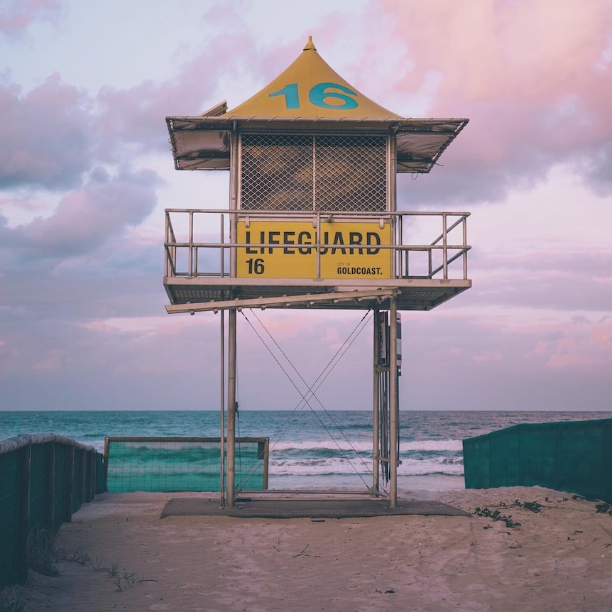 A life guard box on a beach, framed by storm clouds.