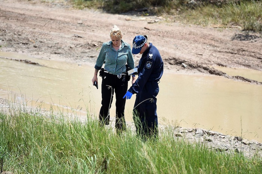 Police examine the scene where two bodies have reportedly were found in Kingston.