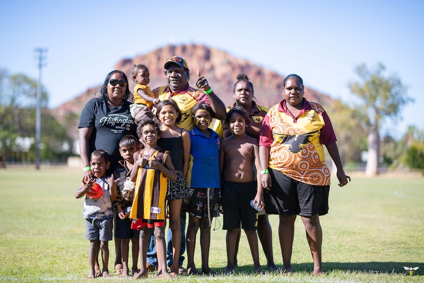 Halls Creek Hawks supporters standing in a group at Kununurra Oval. 