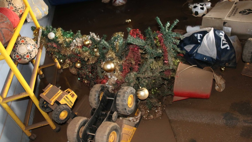 A flood damaged Christmas tree lays among other debris after flood waters ease at Daly River, NT.
