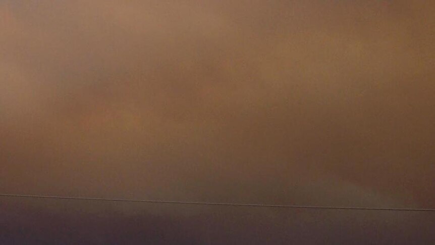 Thick smoke from the Tostaree bushfires covers the sky above Orbost