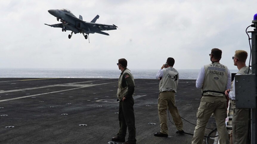 A fighter jet lands on US aircraft carrier Carl Vinson in the South China Sea.