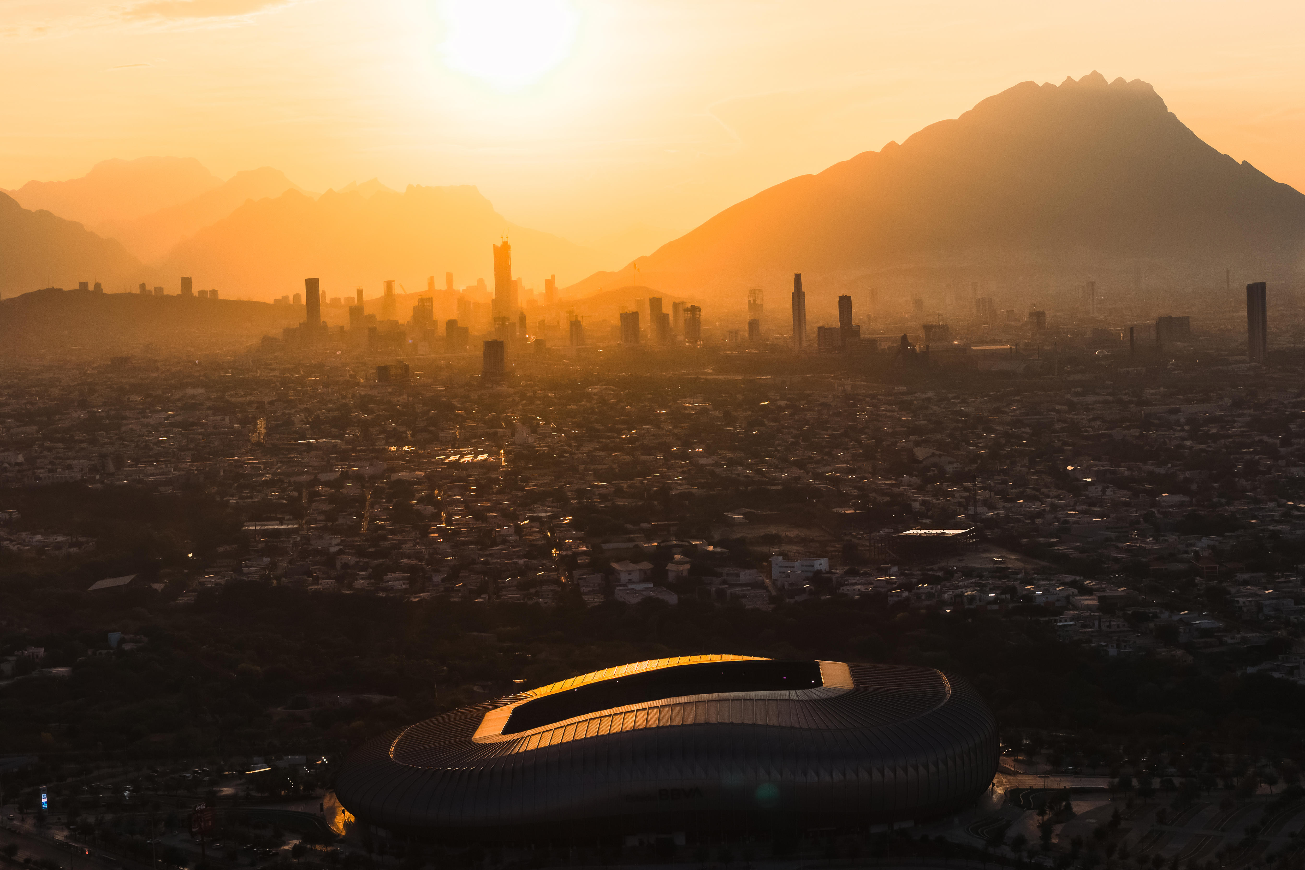 The Monterrey stadium with the city behind it at sunset
