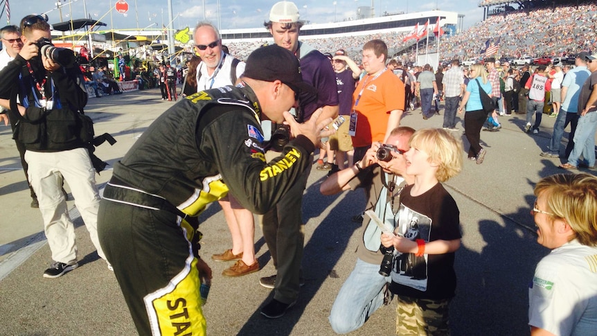 Nascar driver talks to young racing fan
