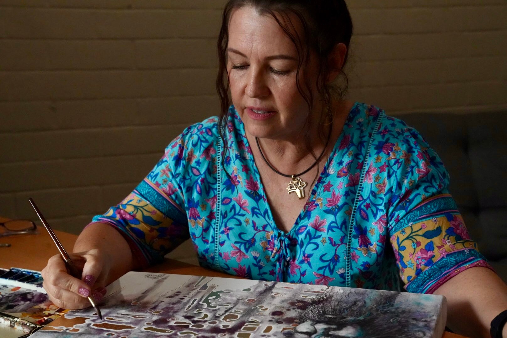 mulher em um vestido azul pintando em uma tela