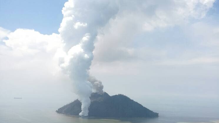 An aerial photograph shows the Kadovar volcano shooting white plumes of smoke tens of kilometres into the air.