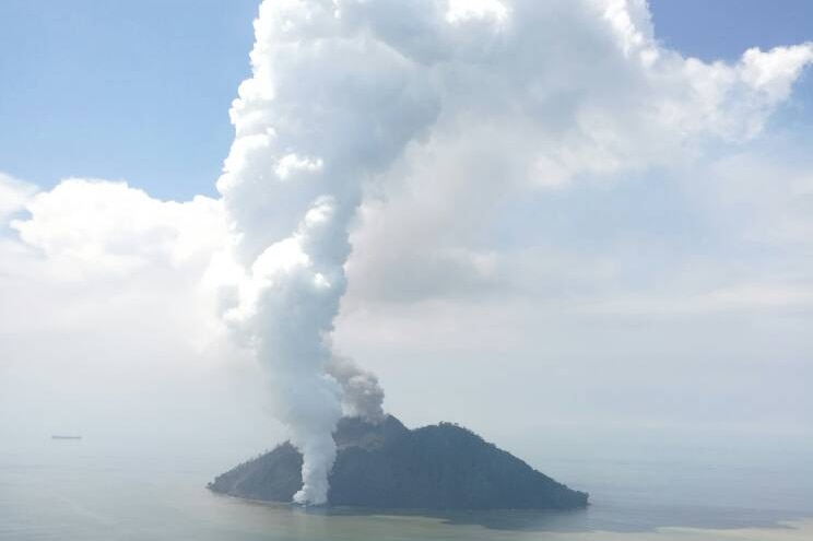 An aerial photograph shows the Kadovar volcano shooting white plumes of smoke tens of kilometres into the air.