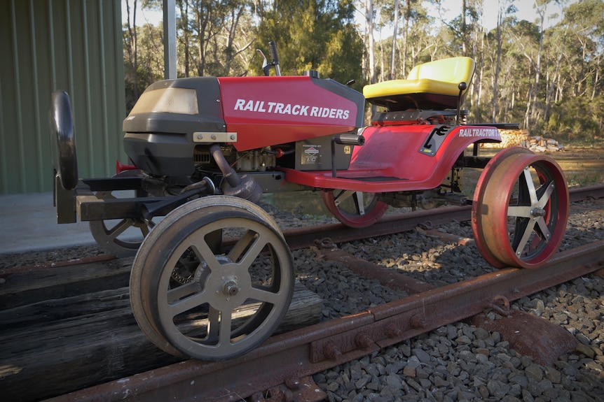 A ride-on lawn mower that has been adapted to ride along railway tracks.