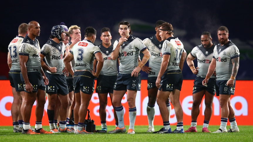 Melbourne Storm players stand in a group during an NRL game against the South Sydney Rabbitohs.