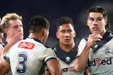 Melbourne Storm players stand in a group during an NRL game against the South Sydney Rabbitohs.