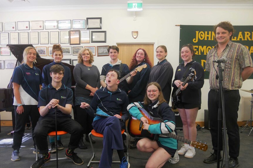 A class filled with students holding musical instruments plus two adult teachers.