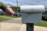 Someone delivers a letter to the letterbox 