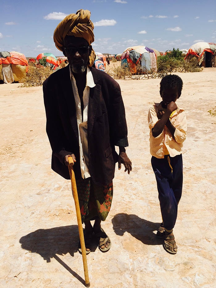 A blind man alongside a boy in a Caynabo IDP camp.