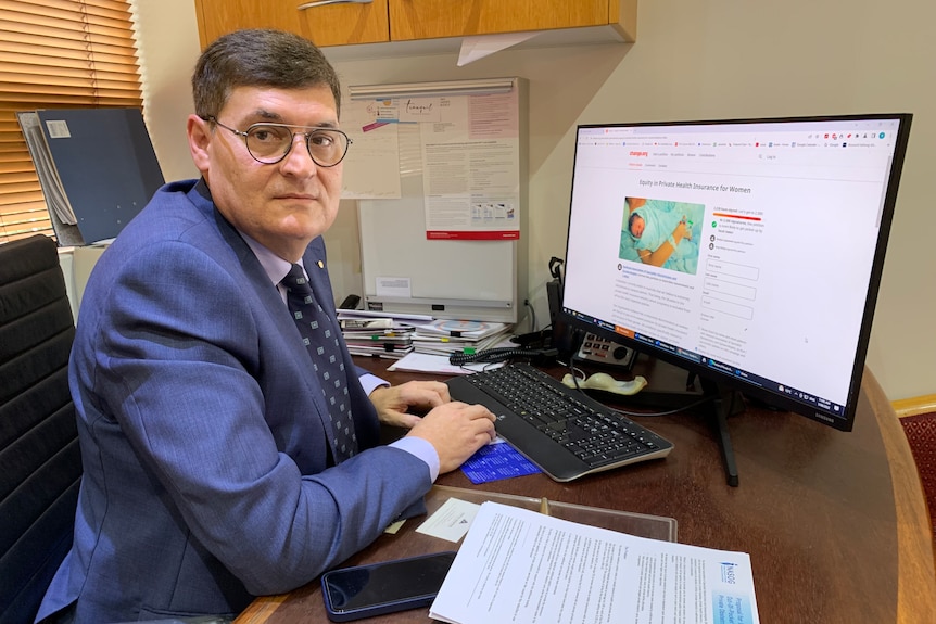 man sitting at a desk with a petition on the screen