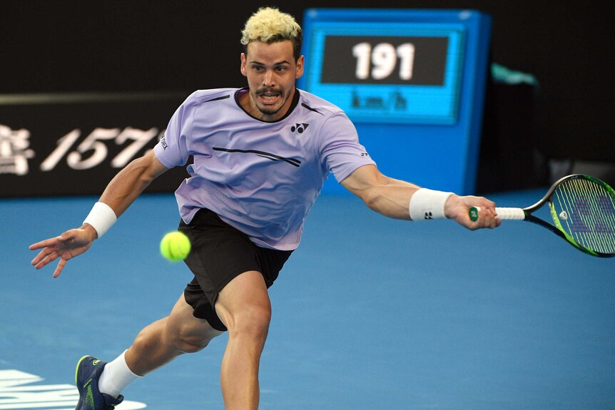 Men's tennis player swings his racquet for a baseline forehand at the Australian Open.