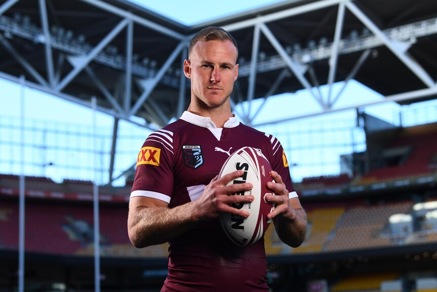 Queensland State of Origin captain Daly Cherry-Evans, holding a ball in two hands, posing for a promotional shoot