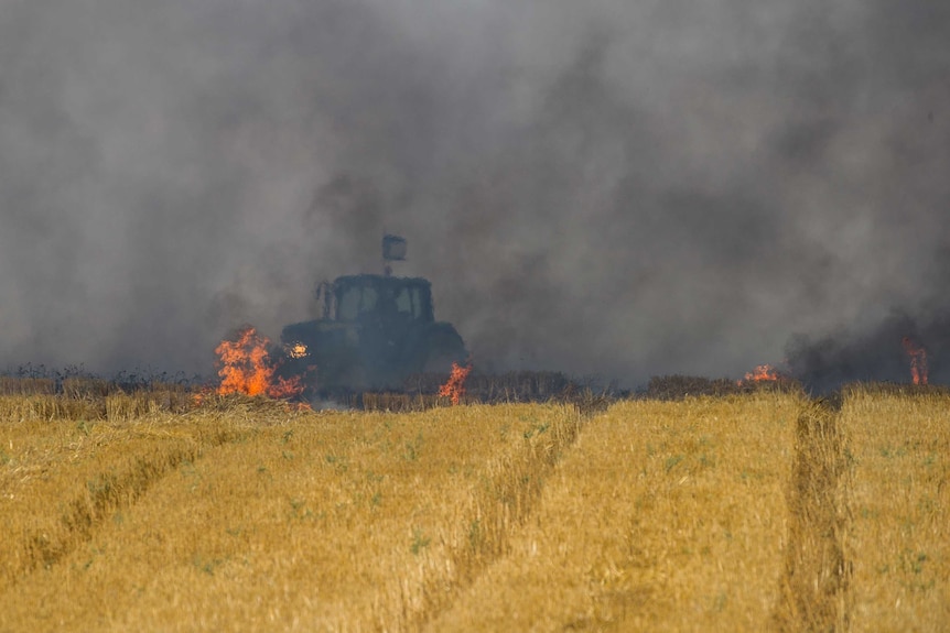 An Israeli tractor works to extinguish a fire started by a kite launched from Gaza.