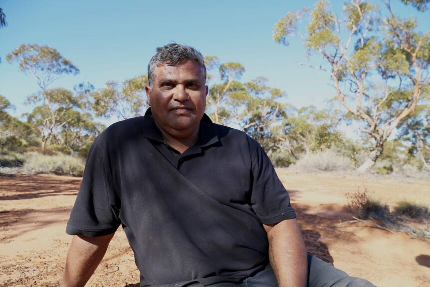 An Anangu man stares down the barrel of the camera
