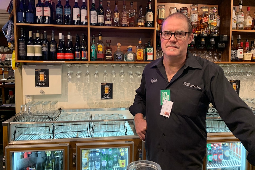 Adelaide hotel owner Damian Peterson stands at the bar.