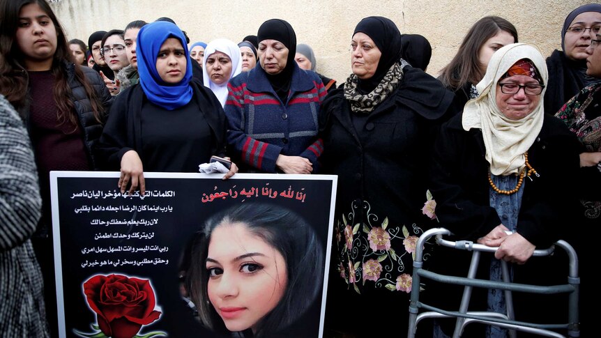 Relatives and friends mourn as they hold a placard with a picture of Leanne Nasser, a victim of the Istanbul nightclub attack.