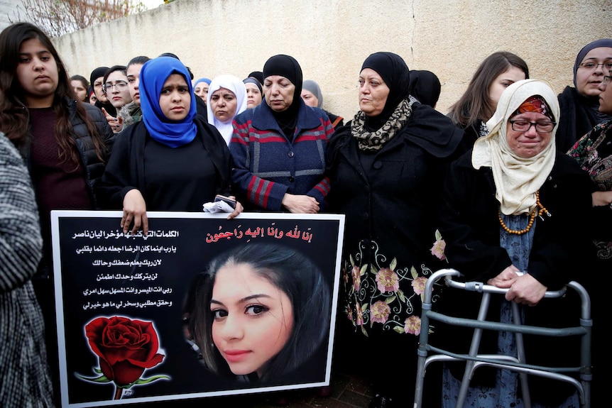 Relatives and friends mourn as they hold a placard with a picture of Layan Nasser, a victim of the Istanbul nightclub attack.