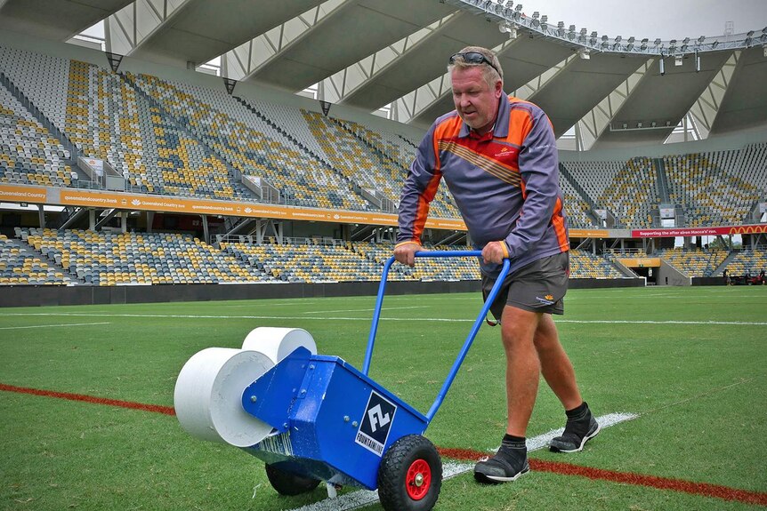 Grounds keeper Bruce Fouracre is marking white lines on the grass at the new Townsville Stadium
