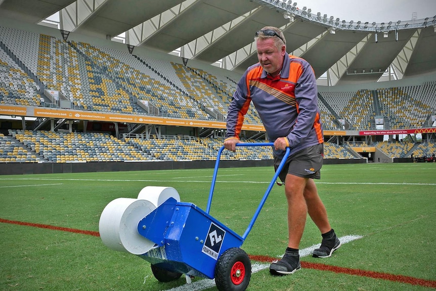 Grounds keeper Bruce Fouracre is marking white lines on the grass at the new Townsville Stadium