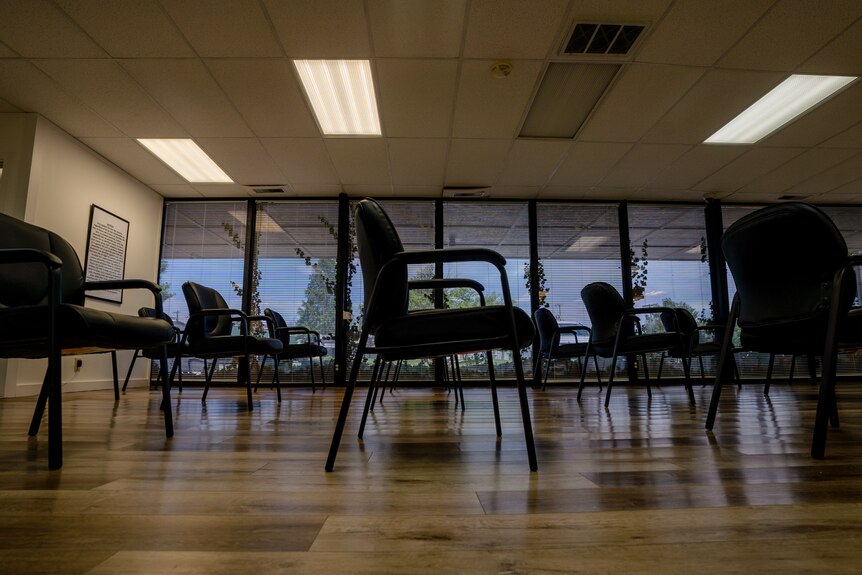 An empty room with spaced apart chairs.