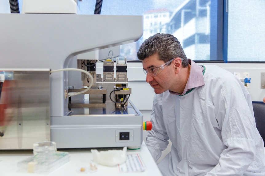 Professor Saso Ivanovski wearing personal protective equipment sitting in medical laboratory.