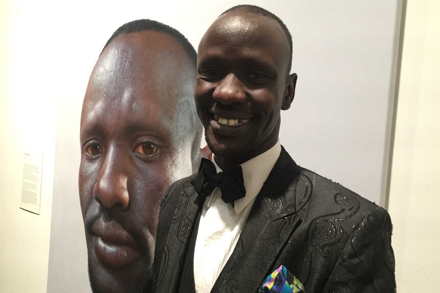 Deng Adut with the portrait of him that has won the People's Choice at the Archibald Prize.