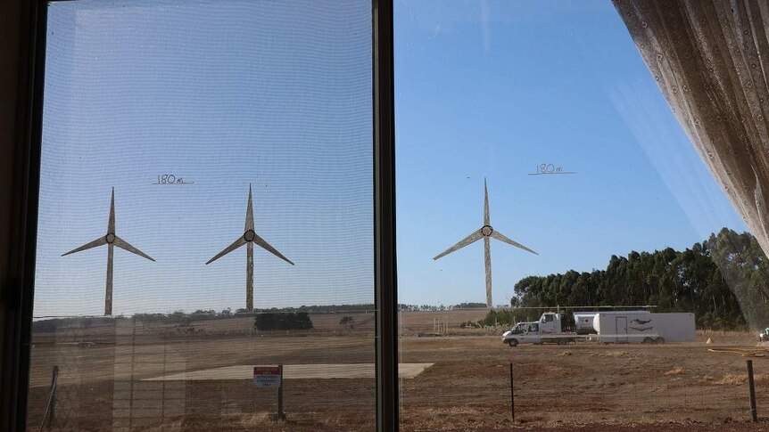 A photo of a window with wind turbines drawn on it showing their future location near a rural airport.