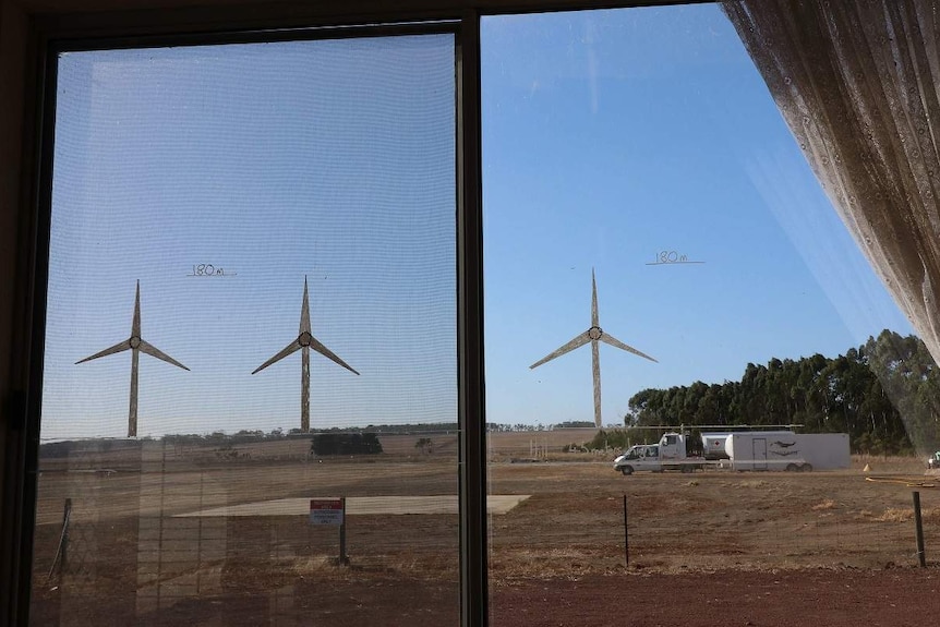 A photo of a window with wind turbines drawn on it showing their future location near a rural airport.