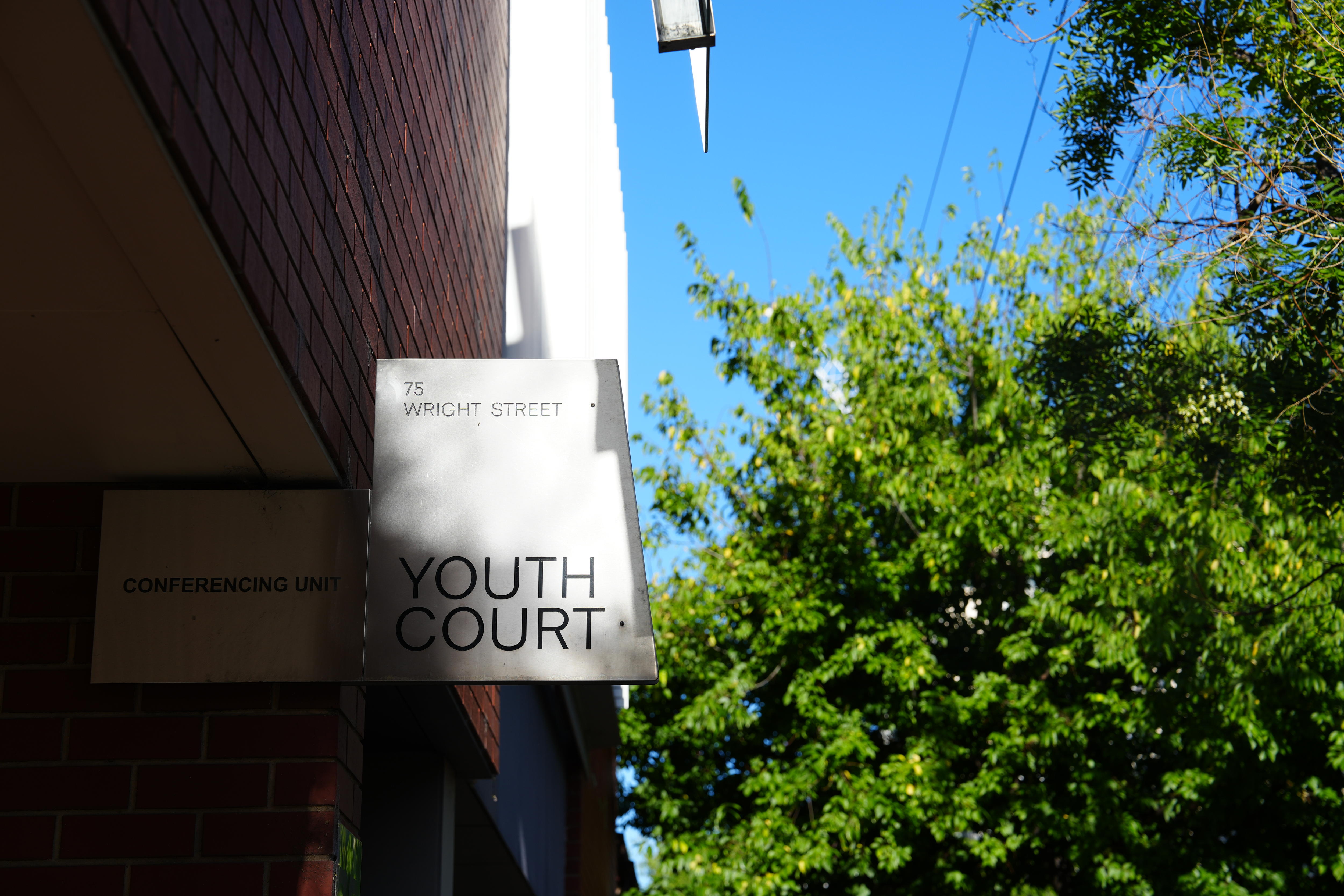 Un letrero de acero inoxidable con las palabras Youth Court y 75 Wright Street