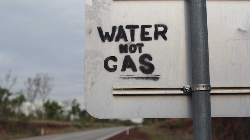 grafitti reading 'water not gas' on a roadsign