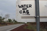 grafitti reading 'water not gas' on a roadsign