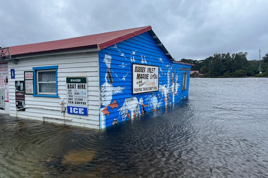 A bait and tackle shop is inundated by flood waters at Sussex Inlet.