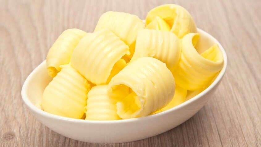A small bowl filled with curls of butter.