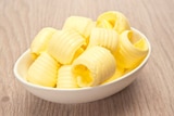 A small bowl filled with curls of butter.