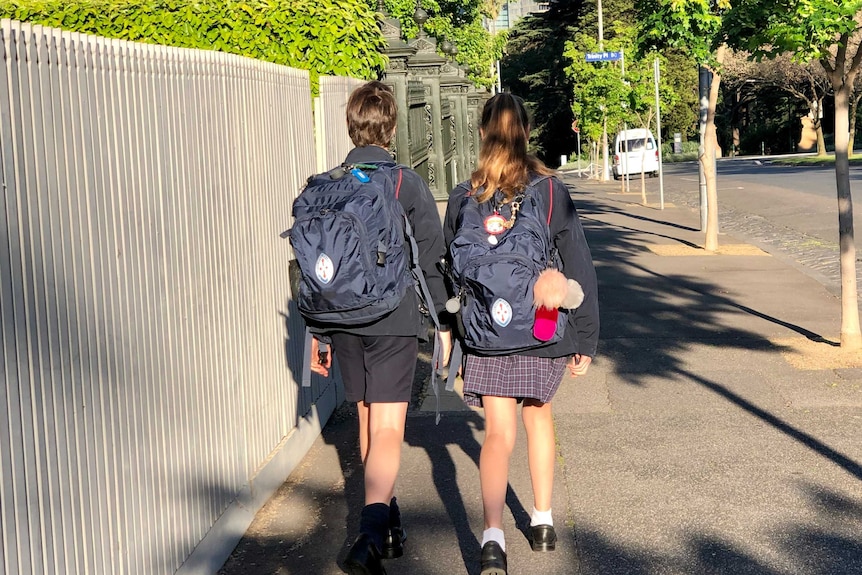 Students walk down a street.