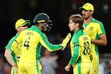 Four Australian male players congratulate each other after dismissing an Indian batter.